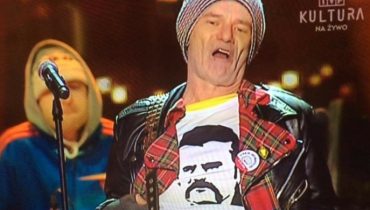 Robert Brylewski w koszulce z Lechem Wałęsą podczas koncertu transmitowanego przez TVP